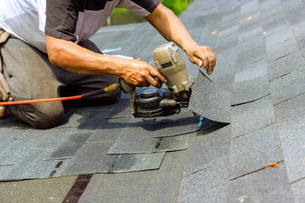 Contractor repairing storm-damaged shingles on Minnesota home to stop active attic leak
